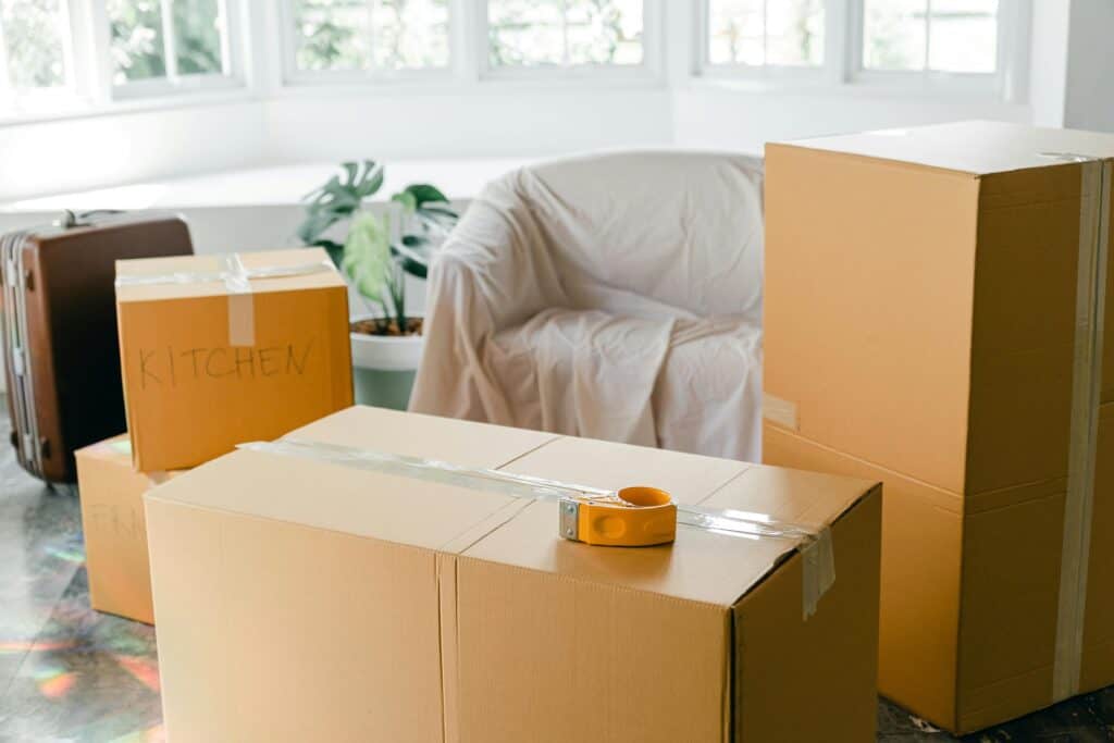 Cardboard boxes with label and wrapped sofa in the concept of moving to Wandsworth.