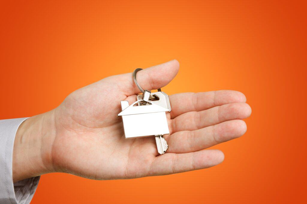 A man's hand holding a key to his new house in the concept of moving to Wandsworth