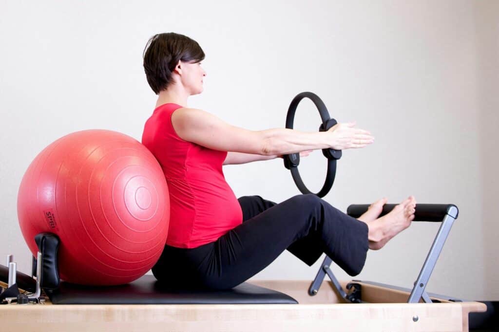 A pregnant woman is exercising in a gym in the concept of 'top services and amenities in Wandsworth'.