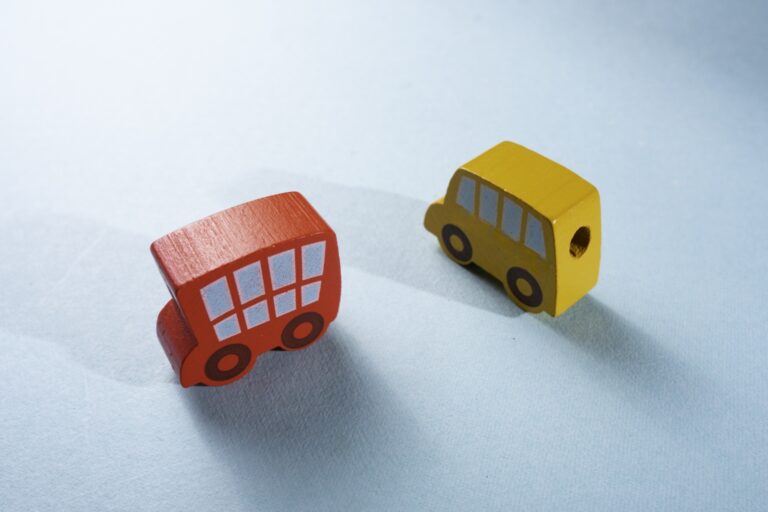 Two wooden vehicle figurines on the table in the concept of 'Differences Between Man and Van Services and Traditional Removals in Wandsworth'.